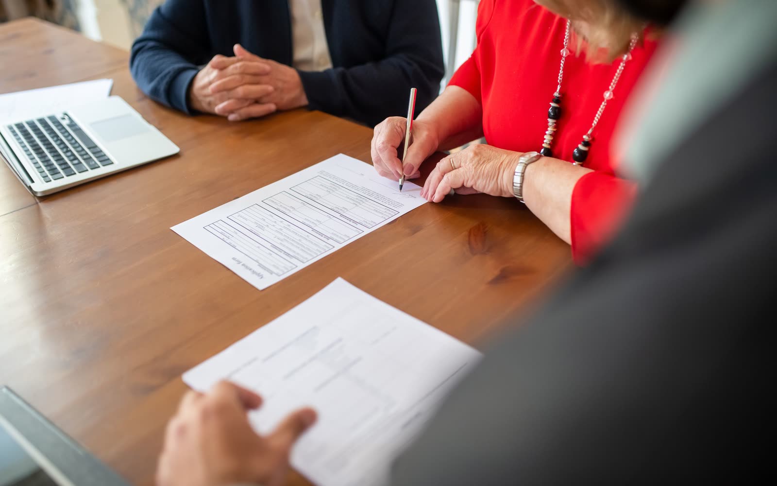 Two people signing closing documents at a table