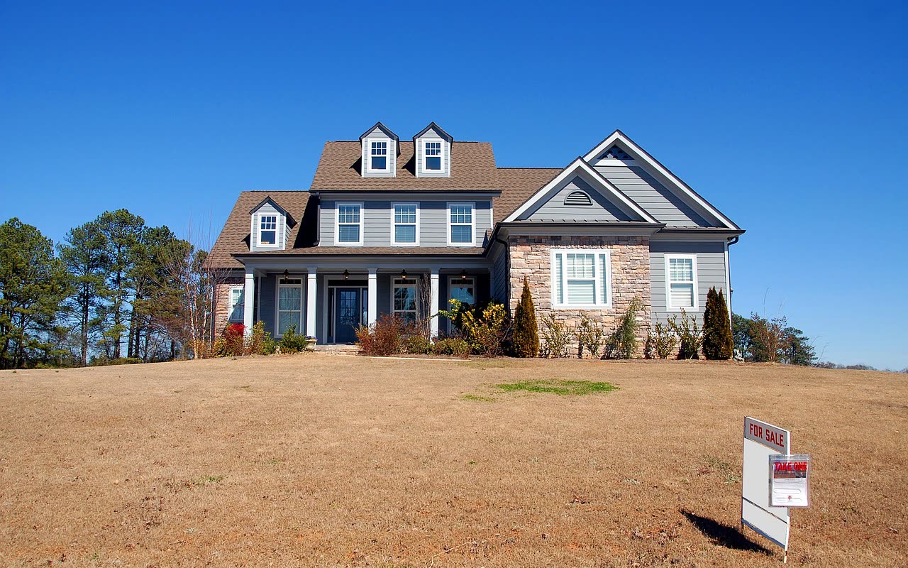 A suburban home with a for-sale sign in the front yard