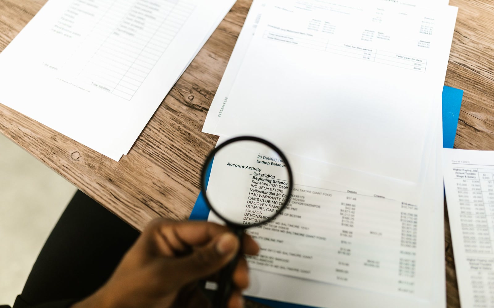 A magnifying glass held over a bank statement