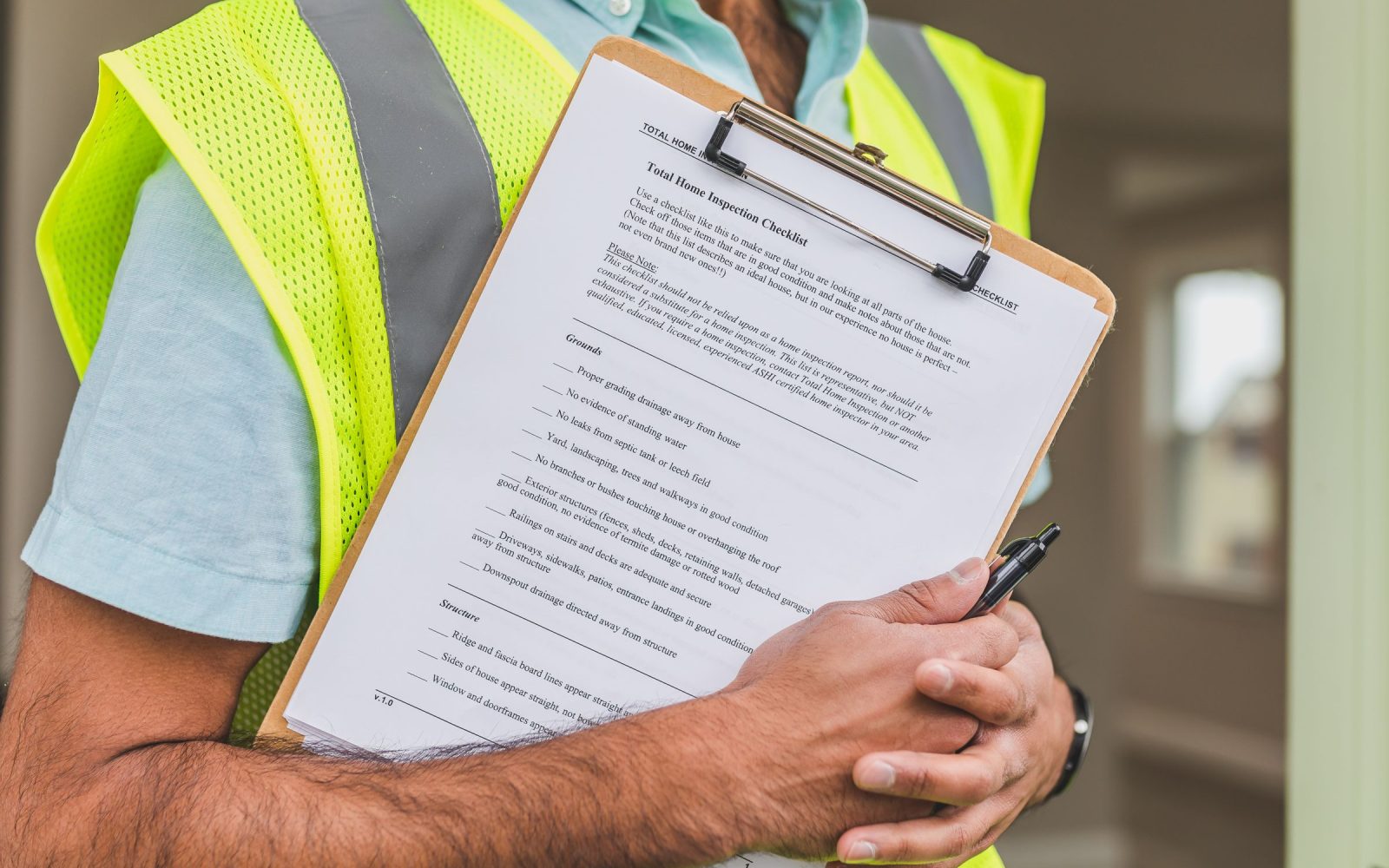 An inspector holding a completed inspection checklist on a clipboard