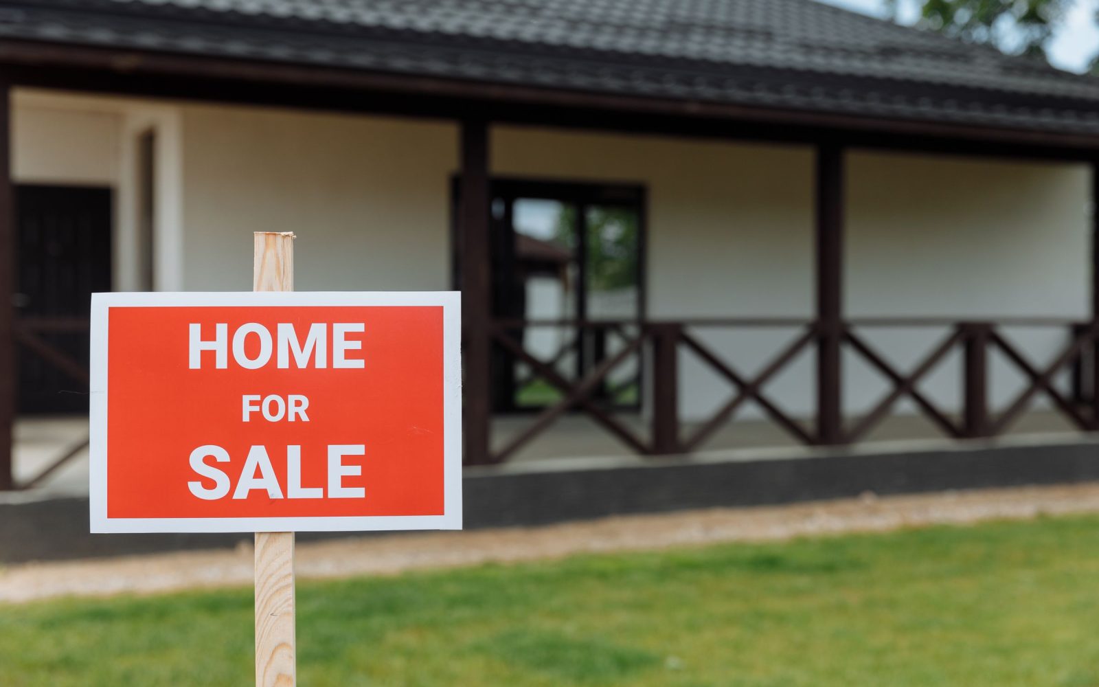 A home for sale sign on a front lawn